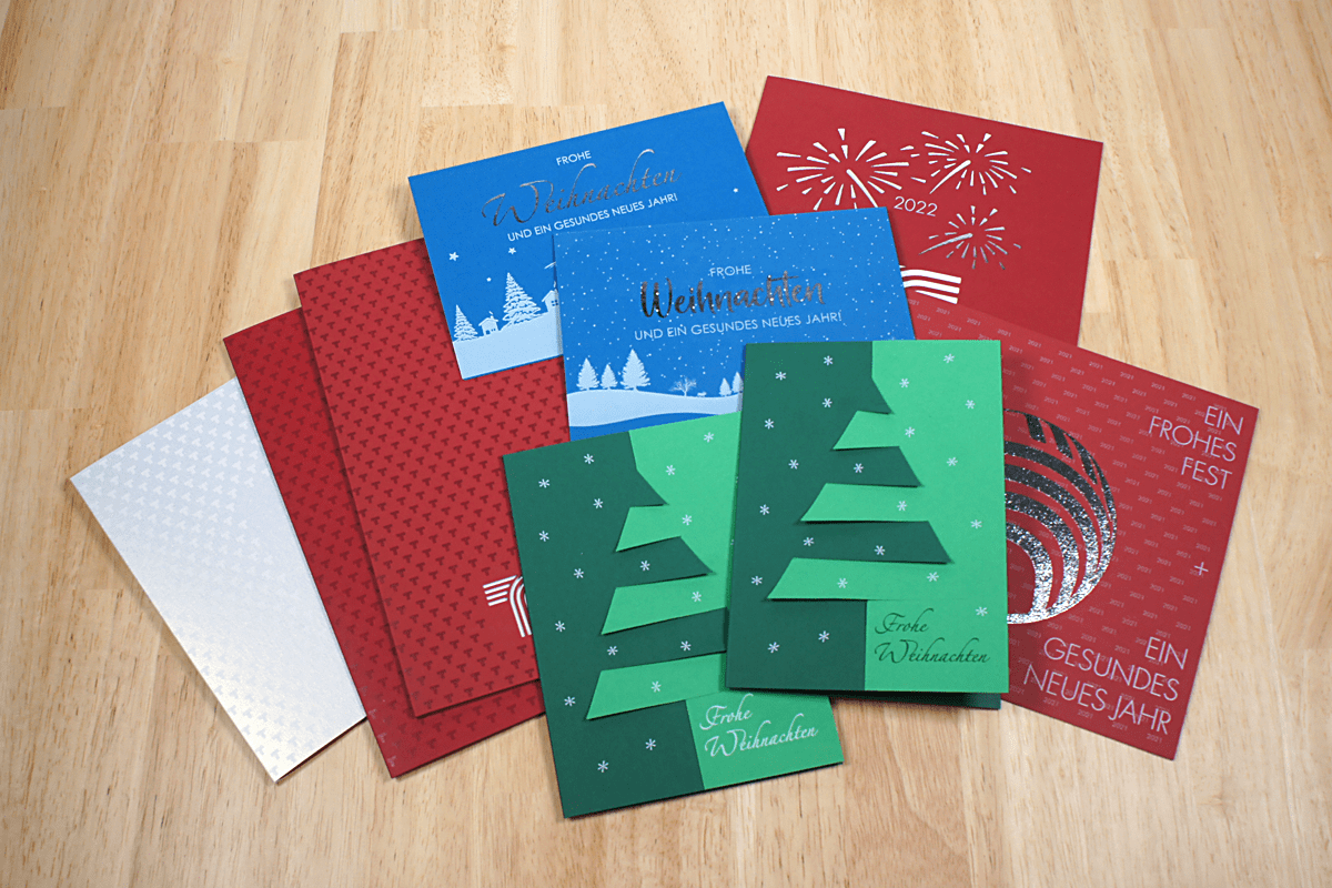 Aufwendig gestaltete Karten aus farbigen Papier mit weißem Druck